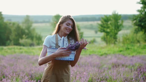 Happy Girl Holding Basket with Lavender Flowers in Field alt