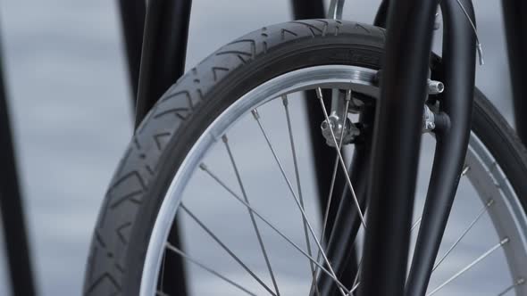 Closeup Front Bicycle Wheel Standing on Shared Parking alt