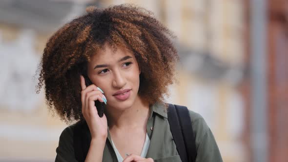 Young African American Woman Irritably Holding Phone to Ear and Displeased Very Hard to Hear alt