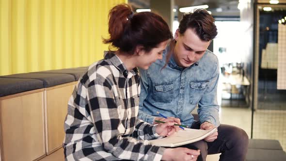 Cute Happy Couple Drawing Something in Notepad alt
