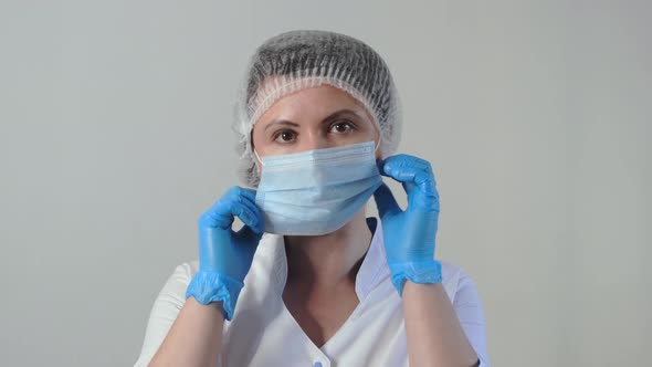 Portrait of Young Tired Caucasian Female Doctor or Nurse Takes Off Her Medical Face Mask