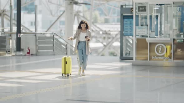 Portrait of Beautiful Young Woman Walking Towards Camera in Airport Terminal alt