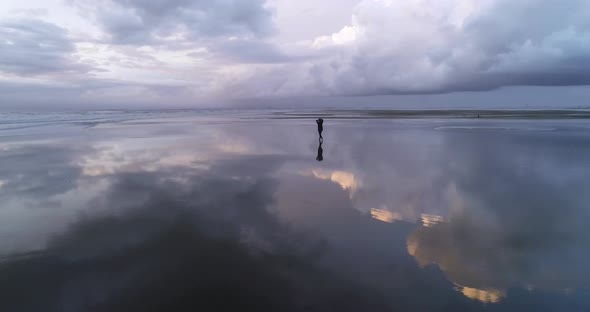 Silhouette of Happy Dreaming Girl Walking on an Empty Beach