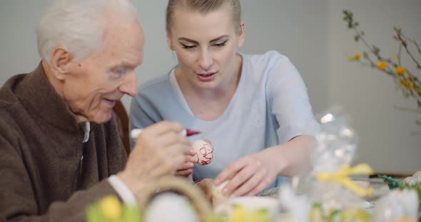Senior Man and Woman Painting Easter Eggs alt