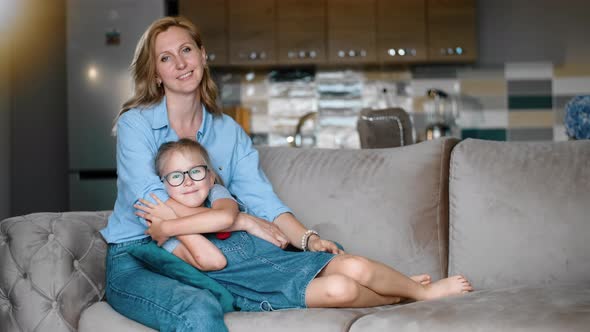Front View of Young Mom Having Good Time with Her Daughter on Couch at Apartment Rbbro alt