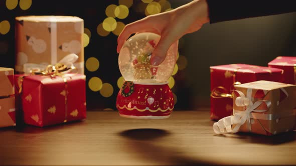 Christmas Snowglobe and Christmas Gifts on Table