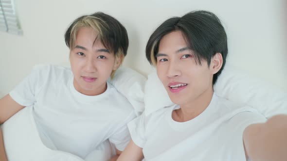 Asian handsome man gay use mobile phone video call online with family. alt