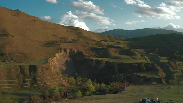 Aerial view of mountain hills, terraces on sunset, countryside landscape with tractor