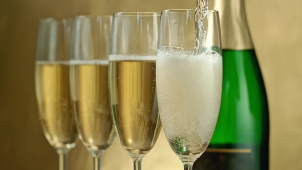 Super Slow Motion Shot of Pouring Champagne on Golden Luxury Background at 1000Fps alt