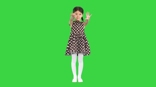Beautiful Young Girl Wearing Polkadot Dress Showing Her Age with Fingers and Pronouncing It To the alt