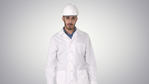 Arab engineer in helmet and white robe walking forward alt