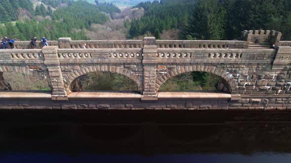 Tourists enjoy a walk along Scar House Reservoir Dam. No release required. alt