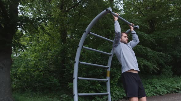 Athlete Using Chin-Up Bar In Forest Gym