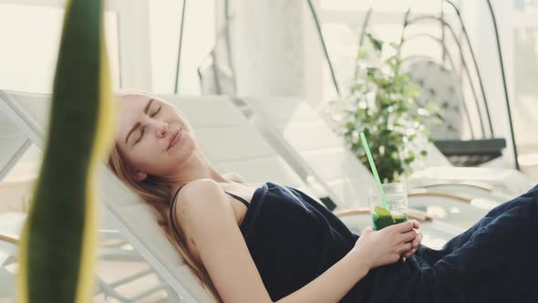 Medium Shot of Woman Lying on a Deck Chair and Relaxing