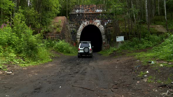 The Car Drives Into a Tunnel in the Forest