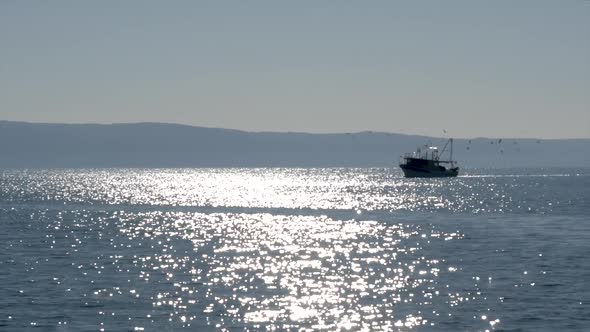 Fishing Boat On Sea With Sun Reflection On Sunny Day