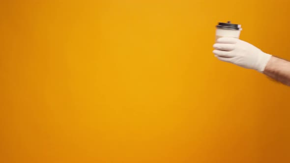 People's Hand Passing One Another Coffee to Go Coffee Delivery Against Yellow Background alt