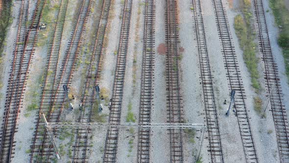 Empty parallel railway tracks in a train station. Rails, ties and ballast of a permanent way alt