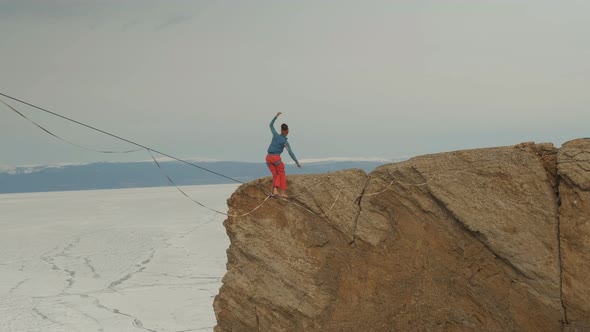 A Young Woman Is on the Slackline at High Altitude