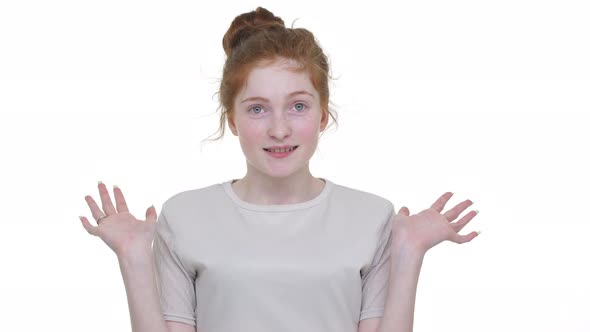 Caucasian Playful Beautiful Girl with Tied Ginger Hair in Topknot Looking on Camera with Shy alt