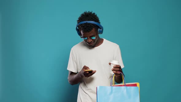 Modern Adult Using Smartphone and Carrying Shopping Bags alt