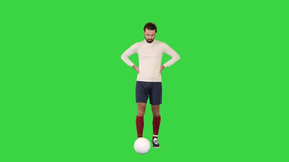 Football Player Walking Slowly and Kicking the Ball on a Green Screen Chroma Key alt