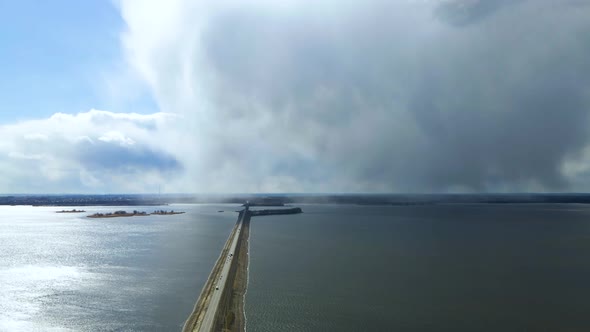 Drone view of landscape of an asphalt road with cars going along the blue river alt