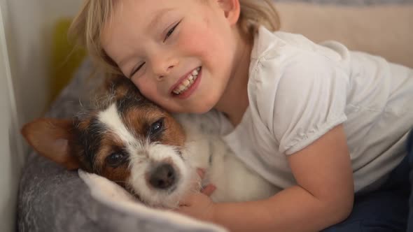 Close Portrait of a Cute Blond Little Boy and His Pet Mongrel Dog alt