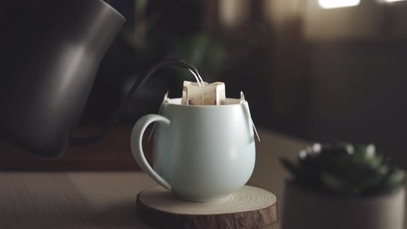 Coffee Drip at Home Concept. Pouring Hot Water from Kettle into a Dripper Bag