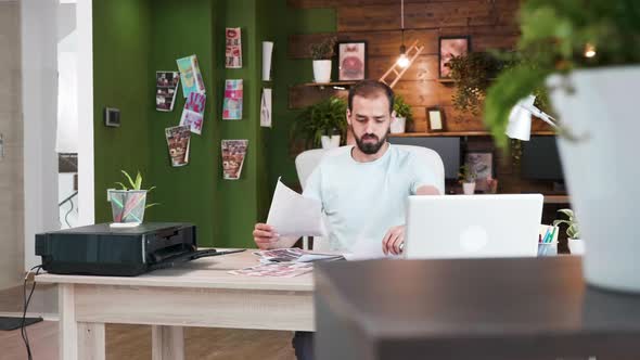 Company Art Director Sitting at This Office Checking His Last Design Sketchges alt