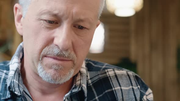 The Face of an Elderly Man Using a Smartphone or Computer