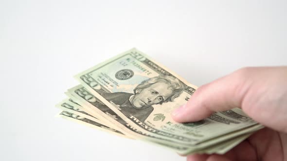 A Hand Holds a Wad of Twentydollar Bills