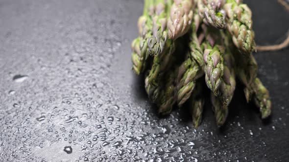 Raw Green Asparagus on Black Slate Background alt