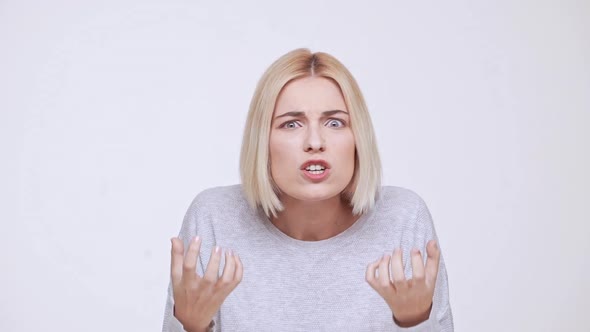 Young Beautiful Shocked Blonde Girl Screaming Over White Background Slow Motion alt