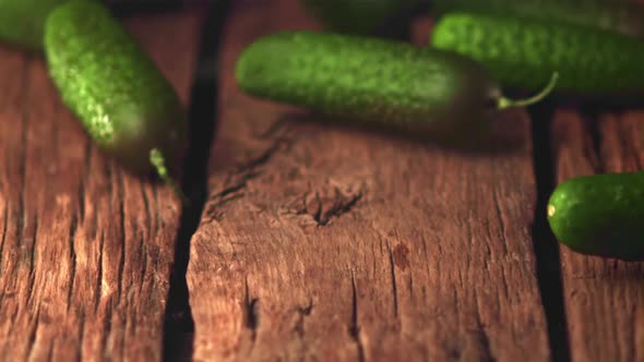 Super Slow Motion Cucumbers Roll on a Wooden Table alt