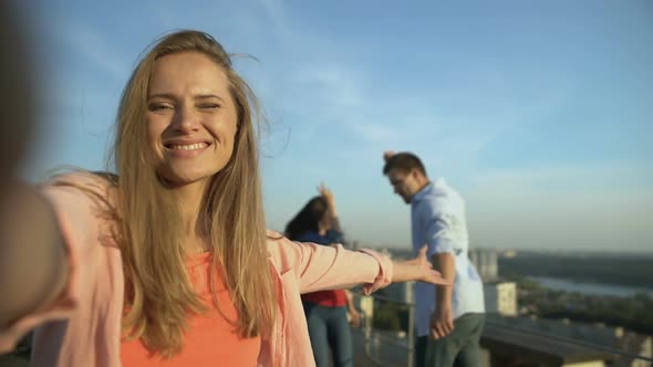 Happy Girl Taking Selfie at Roof Party, Friends Dancing on Background, Relax