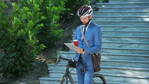 Businessman Holding Cap Of Coffee And Using Digital Tablet