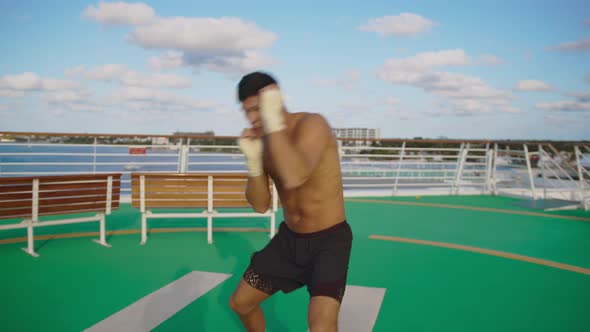 Handsome Strong Sports Man with Beautiful Body Naked Torso Exercising Shadow Boxing on Helipad