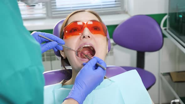 Young Woman on Preventive Examination in Dental Chair at the Dentist. Teeth Care Concept. alt