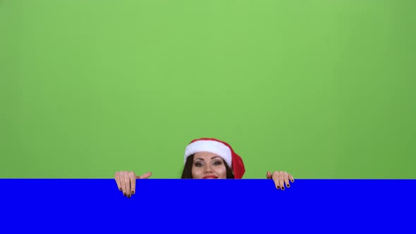 Santa Woman Looks Out of the Blue Board and Shows a Thumbs Up. Green Screen. Slow Motion alt