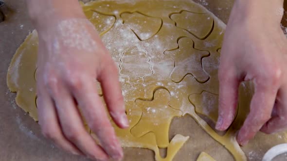 On a Rolled Piece of Dough That Lies on Parchment Cookies are Cut Out with Different Figures By