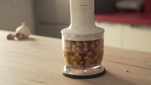 Process of how homemade hummus is made, with garlic, chickpeas, olive oil and spices