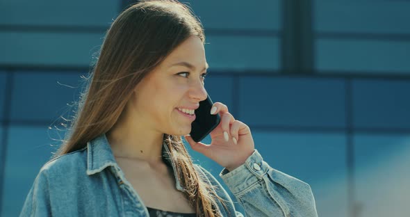 Young Woman Smiling Confident Talking on the Smartphone at Street alt