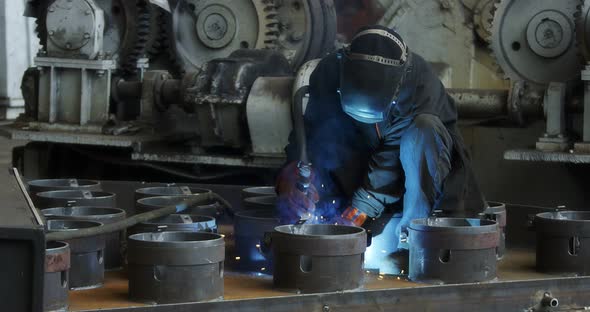 A Professional Welder Makes Steel Structures at the Factory alt