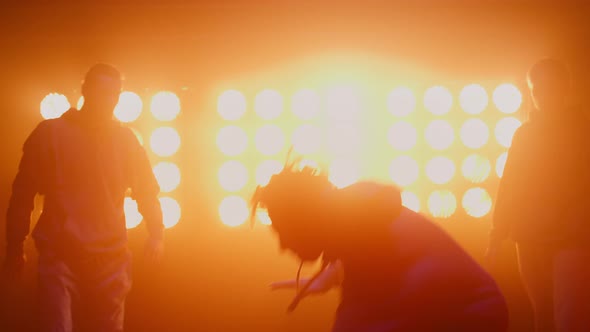 Silhouette Breakdancing Group Dancing in Nightclub alt