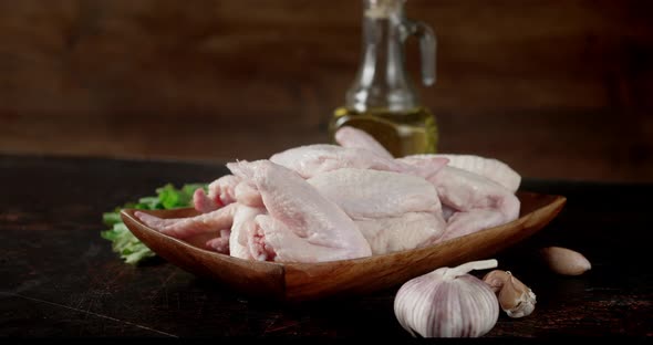 Raw Chicken Pieces of Wings with Garlic and Oil Rotate. alt