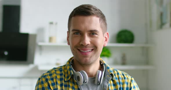 Portrait of Young Happy Man Wearing Wireless Headset on His Neck alt