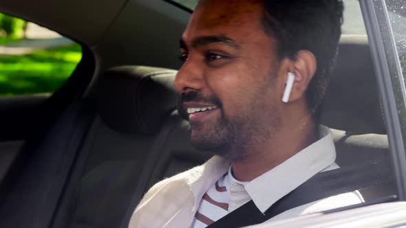 Passenger with Earphones and Cellphone in Taxi Car alt