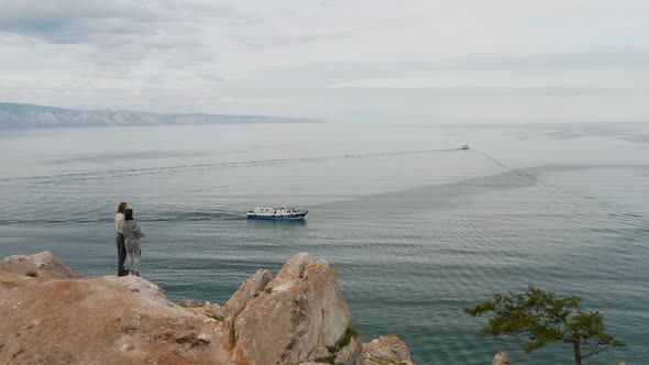 Couple are standing on a cliff Summer Baikal lake Olkhon island alt