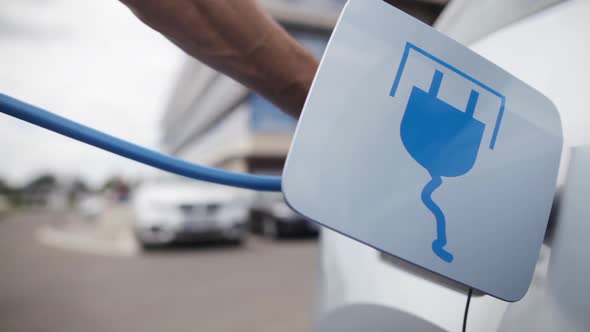 Hand closing the lid of an electrical car, after charging